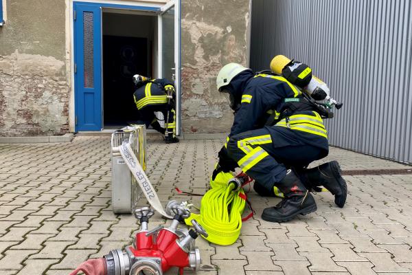 Übung unter Realbedingungen bei Zenner Ventilatoren in Olbernhau - Feuerwehrmann beim Ausrollen